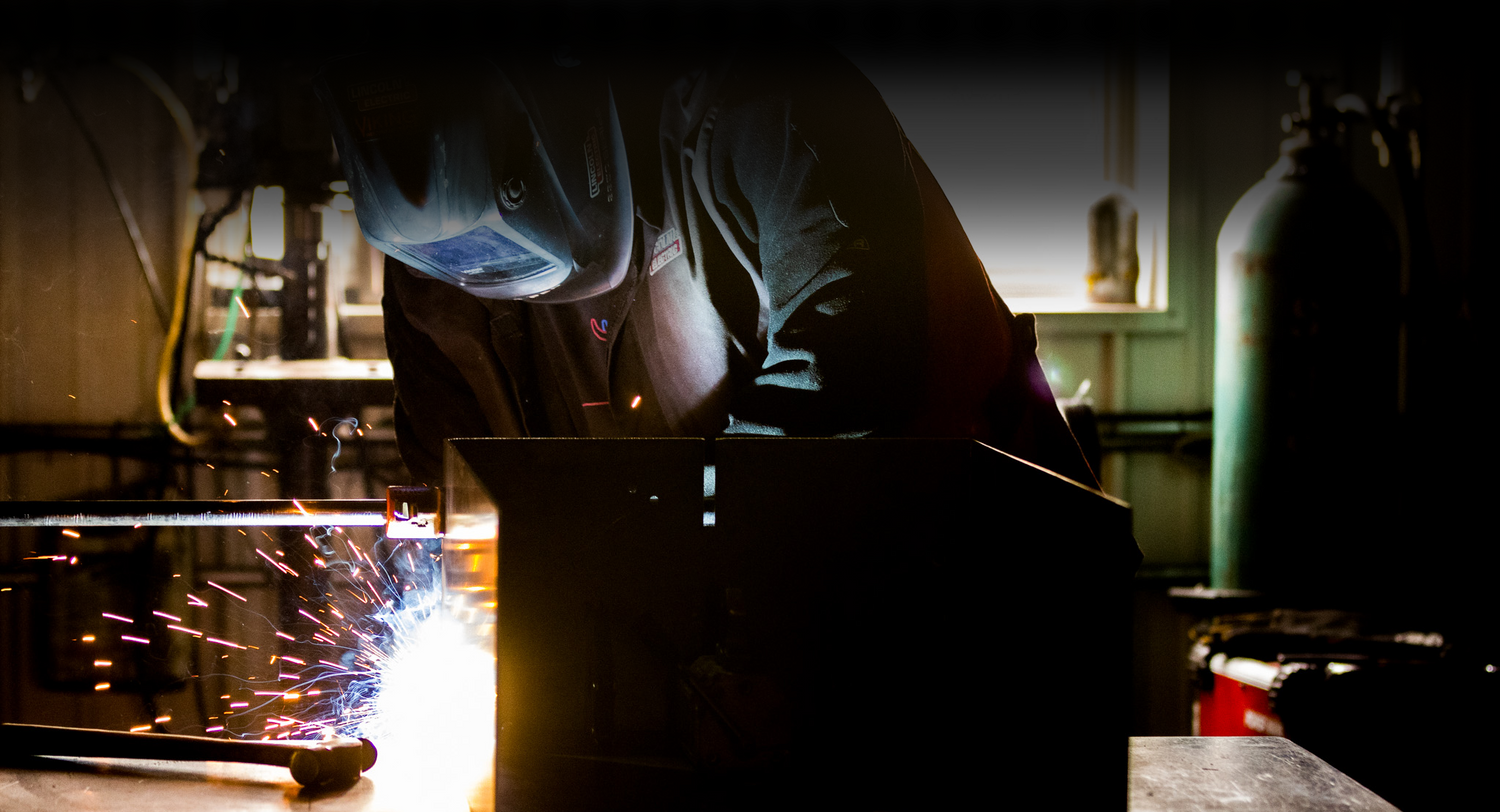 Welder building a grill with sparks flying