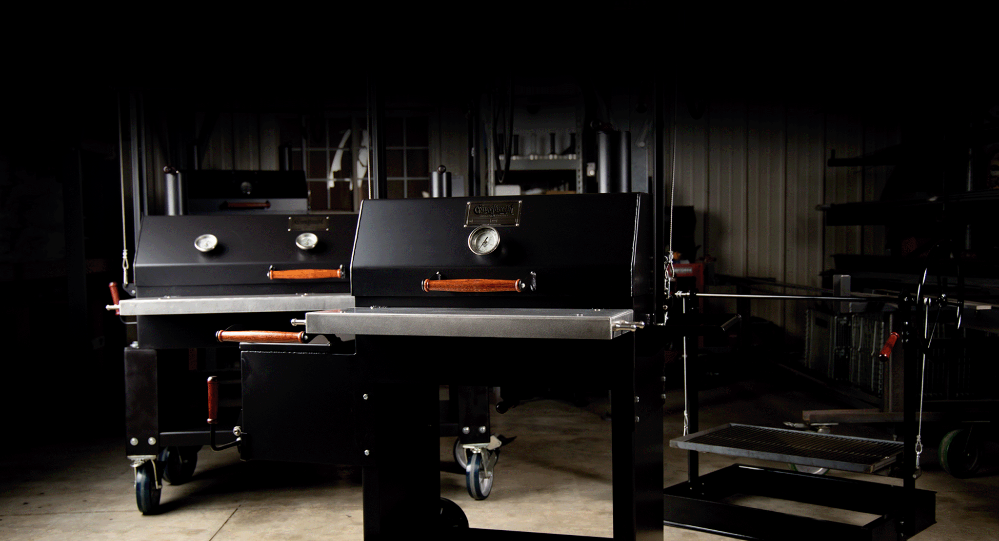The lineup of Engelbrecht grills against the dark background of the production shop