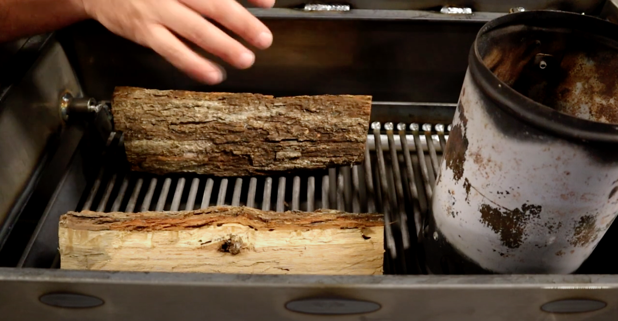 Detail of wood selection on grill grate with coal starter.