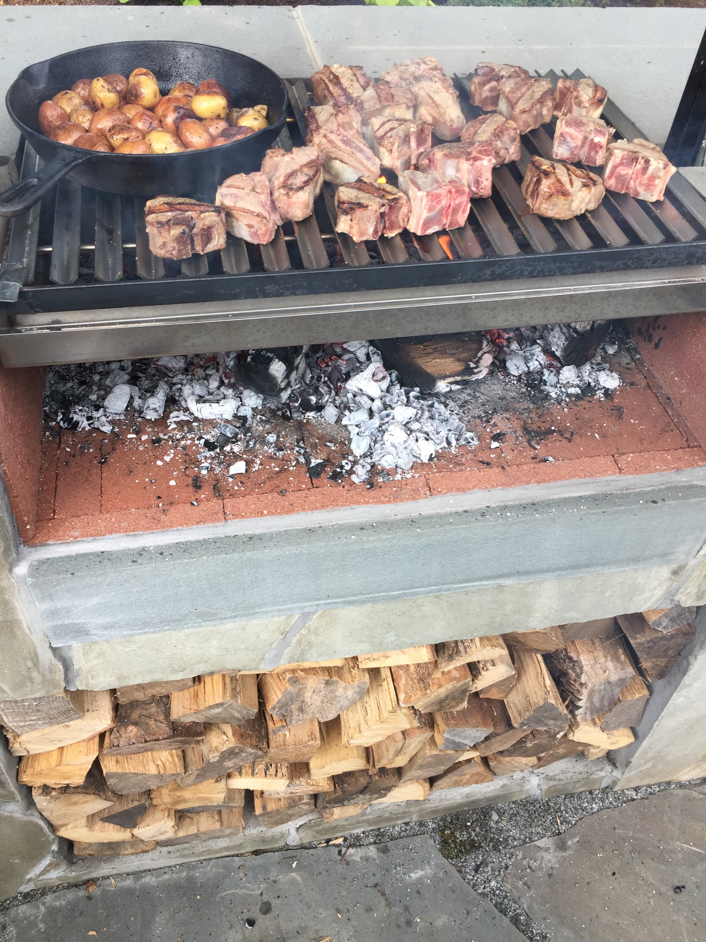 Customer installed Braten Campfire Argentine grill with food cooking