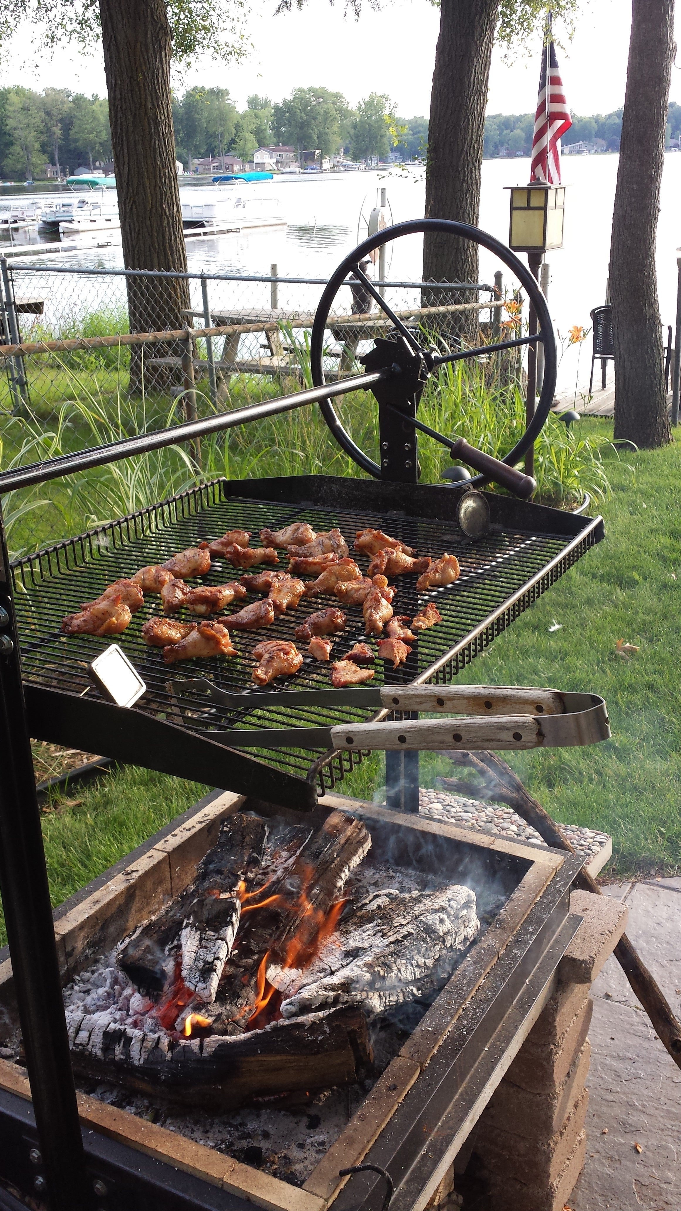 Customer installed Original Braten Campfire grill cooking wings in backyard